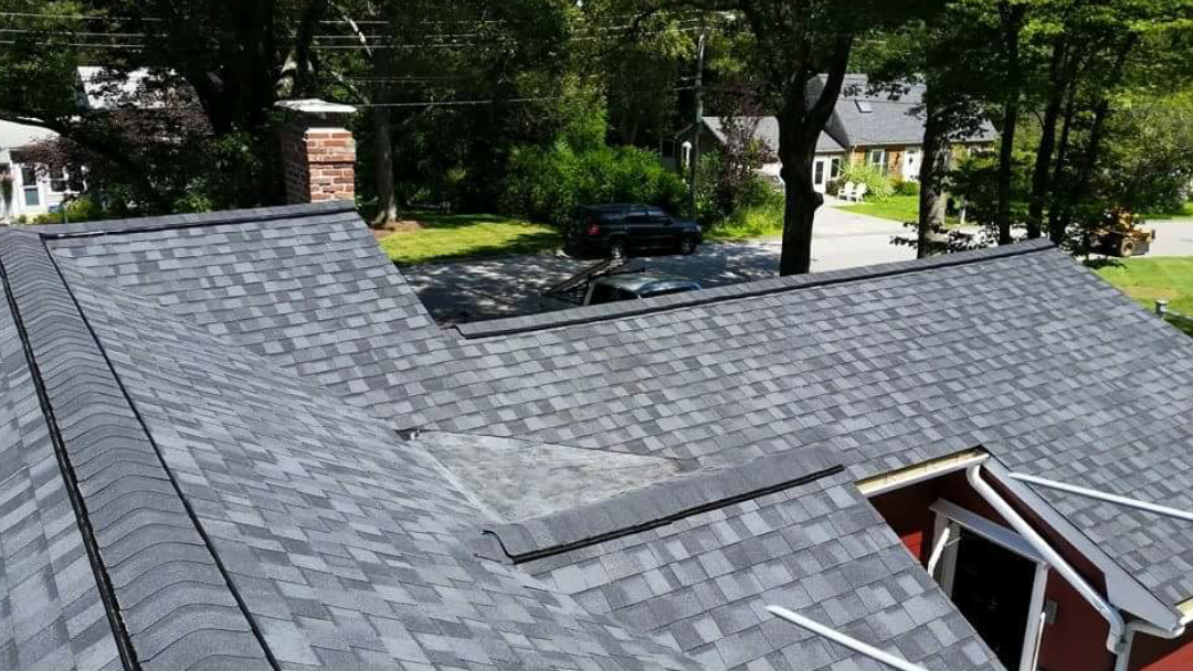 This is an image of just the top of a beautiful new blackish/grayish roof that our South Shore roofing company installed. It is an example of the roof repair, roof replacement, and roof installation work that our South Shore roofing contractors' business does for homes and businesses in Braintree, Duxbury, Marshfield, Pembroke, Quincy, Hanover, Norwell, Plymouth, Weymouth, Scituate, and Cohasset MA